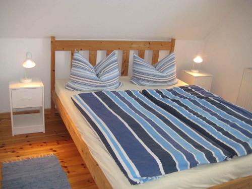 Schlafzimmer mit einem Bett mit blau-weißen gestreiften Kissen in der Unterkunft Apartment in Dierhagen (Ostseebad) 2646 in Dändorf