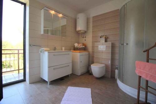 La salle de bains est pourvue de toilettes, d'un lavabo et d'une douche. dans l'établissement Holiday home in Porec/Istrien 10231, à Poreč