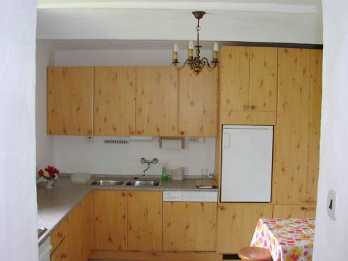VlciceにあるHoliday home in Vlcice u Trutnova 2323のキッチン(木製キャビネット、テーブル、シャンデリア付)