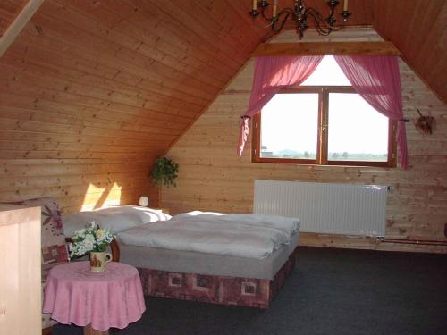 VlciceにあるHoliday home in Vlcice u Trutnova 2323の屋根裏のベッドルーム(ベッド2台、テーブル付)