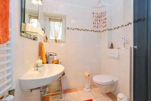 La salle de bains blanche est pourvue d'un lavabo et de toilettes. dans l'établissement Apartment Bergen auf Rugen 1, à Mölln-Medow