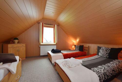 a attic room with three beds and a window at Apartment Bergen auf Rugen 1 in Bergen auf Rügen
