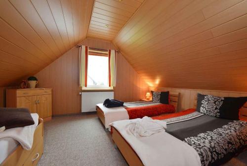 Zimmer im Dachgeschoss mit 3 Betten und einem Fenster in der Unterkunft Apartment Bergen auf Rugen 1 in Mölln-Medow