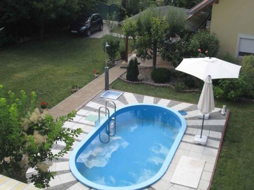 an outdoor swimming pool with an umbrella and an umbrella at Holiday Home Gyenesdias 5 in Gyenesdiás