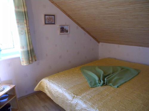 a bedroom with a bed with a green pillow on it at Holiday home in Balatonmariafürdo 19321 in Balatonmáriafürdő