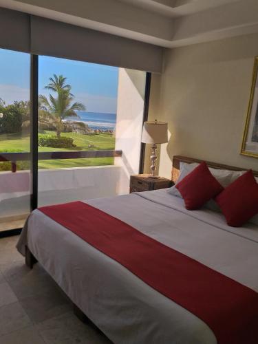 a bedroom with a large bed with a view of the ocean at Mayan Vidanta departamento 2 recámaras 2 baños SERVICIO DE PLAYA in Acapulco