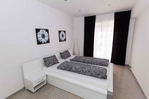 a white room with two beds and a window at Apartment Crikvenica 20 in Crikvenica