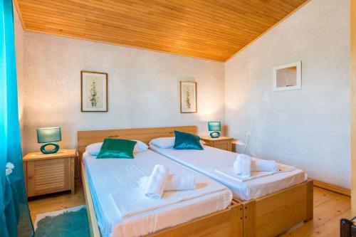 een slaapkamer met 2 bedden en groene kussens bij Apartment Privlaka 12 in Privlaka