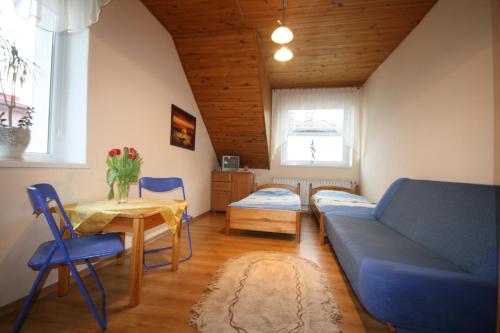 uma sala de estar com um sofá azul e uma mesa em Pokoje Klaudia em Darłowo