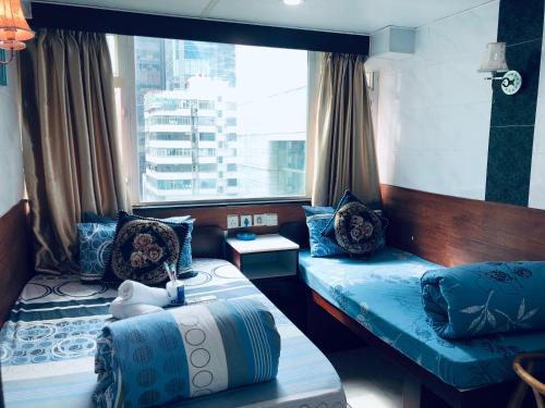 een kamer met 2 bedden en een raam bij United Co-Operate Guest House (7/F) in Hong Kong