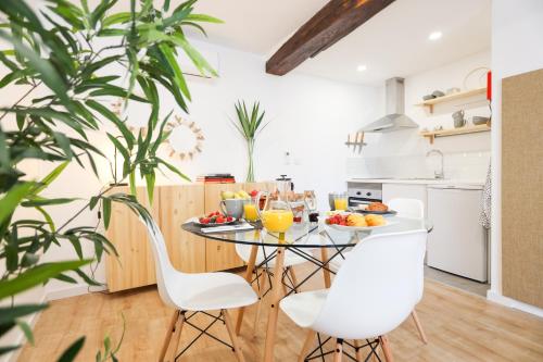 a kitchen with a glass table and white chairs at Casa da Praça in Bragança