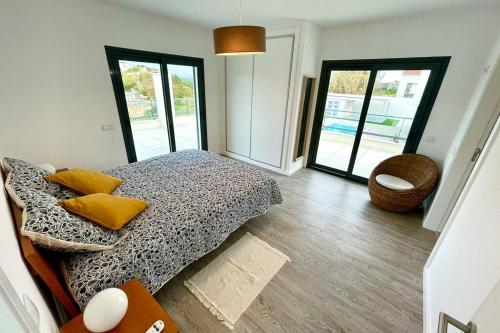 Un dormitorio con una cama con almohadas amarillas. en New and modern 3 bedroom Villa with private heated pool near Nazaré, en São Martinho do Porto