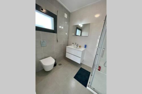 a bathroom with a toilet and a sink and a shower at New and modern 3 bedroom Villa with private heated pool near Nazaré in São Martinho do Porto