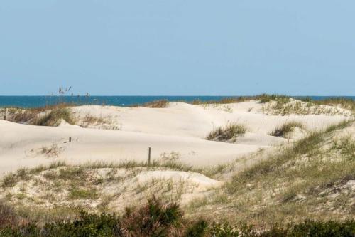 a group of sand dunes with the ocean in the background at Ocean Aire in Knotts Island