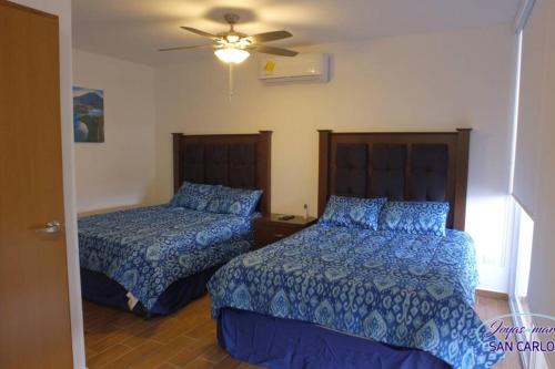 a bedroom with two beds and a ceiling fan at Departamento Turquesa 3 joyas de mar San Carlos in San Carlos