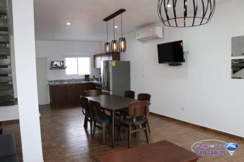 a kitchen and dining room with a table and chairs at Departamento Turquesa 3 joyas de mar San Carlos in San Carlos