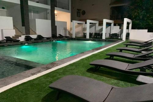 a swimming pool with lounge chairs in a building at Departamento Turquesa 4 Joyas de San Carlos in San Carlos