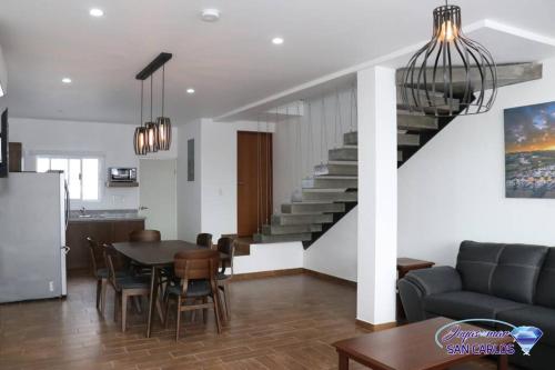 a living room with a table and a staircase at Departamento Turquesa 4 Joyas de San Carlos in San Carlos