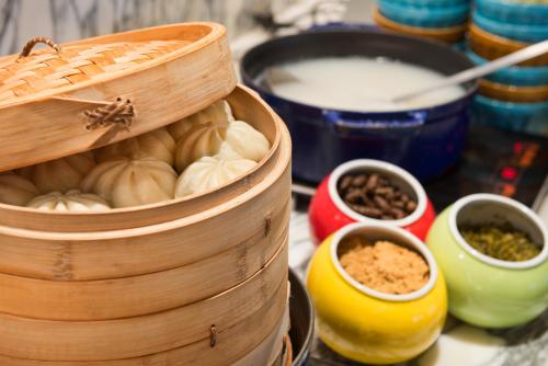 a wooden bowl of food with bowls of ingredients at Hotel Indigo Shanghai On The Bund by IHG in Shanghai