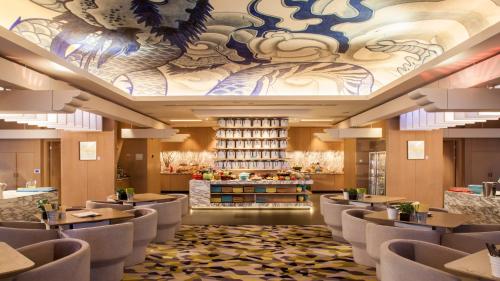 a restaurant with chairs and a ceiling with a mural at Hotel Indigo Shanghai On The Bund by IHG in Shanghai