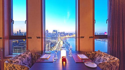a table in a restaurant with a view of a city at Hotel Indigo Shanghai On The Bund by IHG in Shanghai