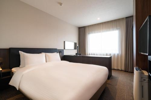 Een bed of bedden in een kamer bij Goi Grand Hotel