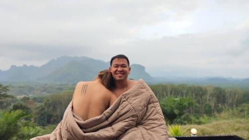 a man wrapped in a blanket with a woman at Por Sampao Camp&Resort in Ban Pha Saeng Lang