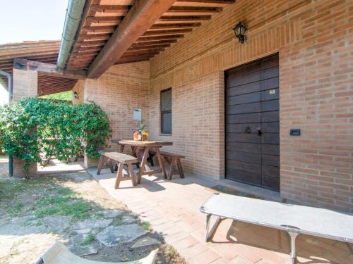 PucciarelliにあるLarge Farmhouse in Castiglione del Lago with Poolのピクニックテーブル付きのパティオ、黒いガレージドア