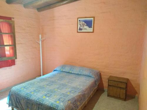 Dormitorio pequeño con cama y mesa en Hospedaje Cabaña Lemos TUNUYAN en Tunuyán