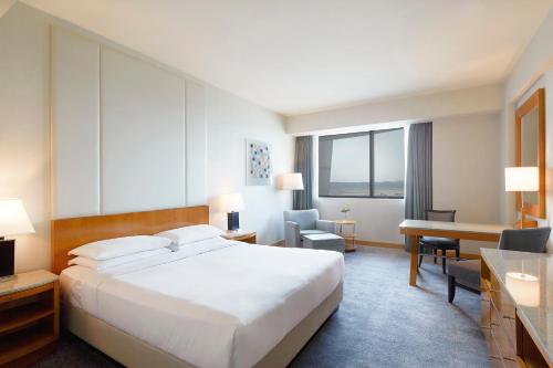 um quarto de hotel com uma cama grande e uma secretária em Grand Hyatt Incheon em Incheon