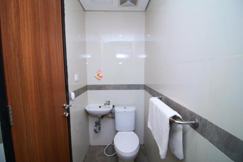 a bathroom with a toilet and a sink at Bale Resident in Jakarta