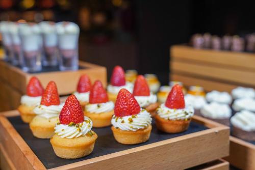 a tray of cupcakes with strawberries on top of them at Crowne Plaza Shenzhen Futian, Near to Shenzhen Convention&Exhibition Centre, Shenzhen Stock Exchange and Shenzhen Civic Center, Outdoor Heated Pool in Shenzhen