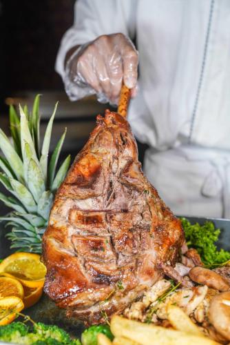 a person holding a piece of meat on a plate of food at Crowne Plaza Shenzhen Futian, Near to Shenzhen Convention&Exhibition Centre, Shenzhen Stock Exchange and Shenzhen Civic Center, Outdoor Heated Pool in Shenzhen