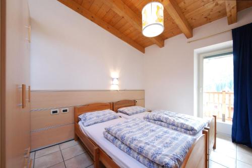 カナツェーイにあるAppartamento Sissiのベッドルーム1室(ベッド2台、窓付)