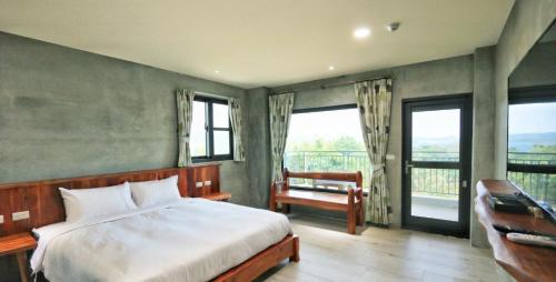 a bedroom with a bed and a balcony with windows at 里夏民宿.墾丁後壁湖 in Hengchun