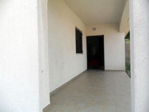 an empty hallway of a white building with a doorway at Studio Apartment in Palit with Sea View, Terrace, Wi-Fi (4606-1) in Mundanije