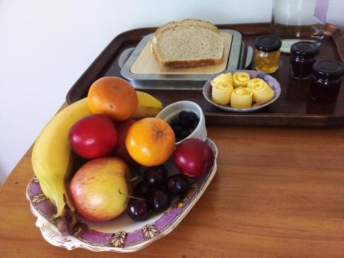 a tray with a bowl of fruit on a table at Catlins Retreat B & B in Owaka