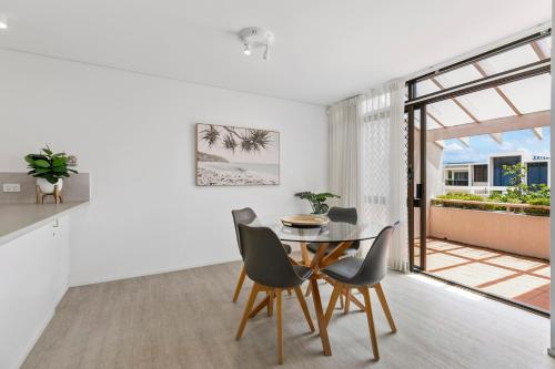 a kitchen and dining room with a table and chairs at The Noosa Apartments in Noosa Heads