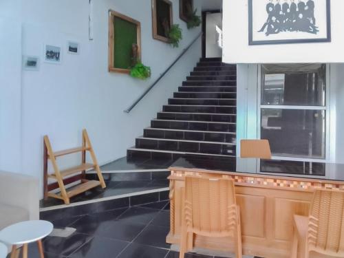 a room with stairs and a table and chairs at Koolkost near DPRD Kabupaten Subang in Subang