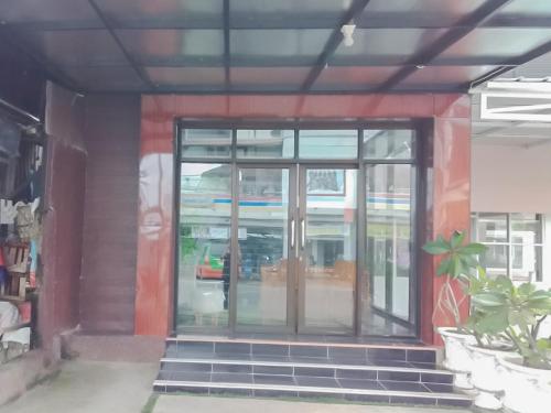 einen Eingang zu einem Gebäude mit einer Glastür in der Unterkunft Koolkost near DPRD Kabupaten Subang in Subang