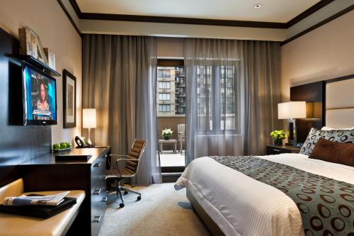 a hotel room with a bed and a desk and a computer at The Pearl Hotel in New York