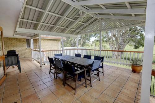 a large screened porch with a table and chairs at Retreat on Gleeson in Forster