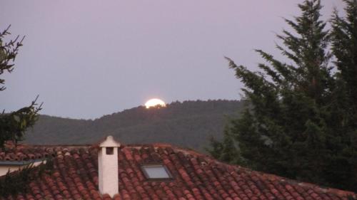 a sun setting over a roof of a house at Casa Tau in Larrasoaña