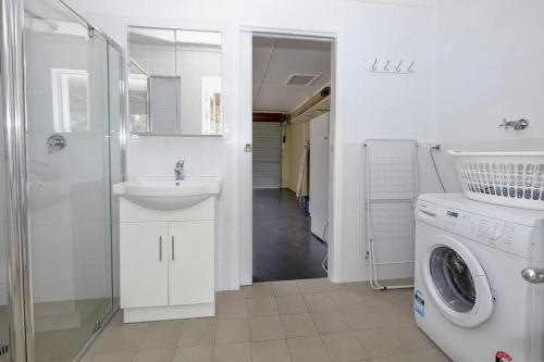a bathroom with a sink and a washing machine at Retreat on Gleeson in Forster