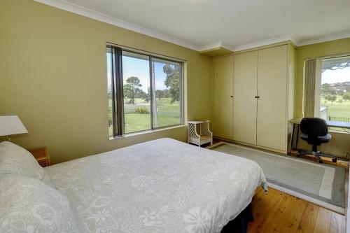 Un dormitorio con una cama y una ventana y una silla. en Retreat on Gleeson, en Forster