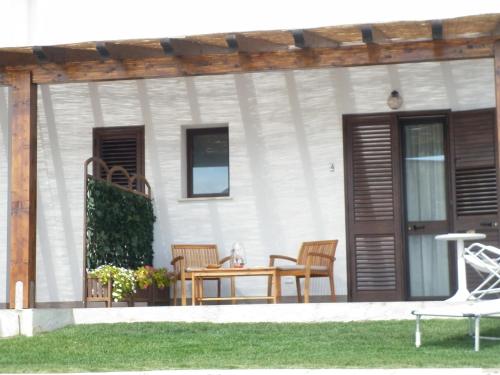 a patio with a table and chairs on a house at Villa Al Mare Guest House in Tre Fontane
