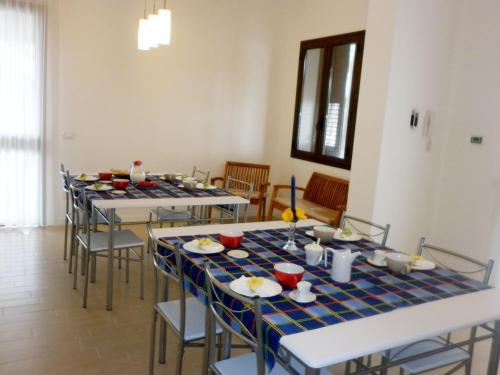a dining room with tables and chairs with food on them at Villa Al Mare Guest House in Tre Fontane