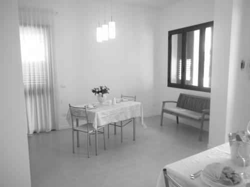 a dining room with a table and chairs and a window at Villa Al Mare Guest House in Tre Fontane