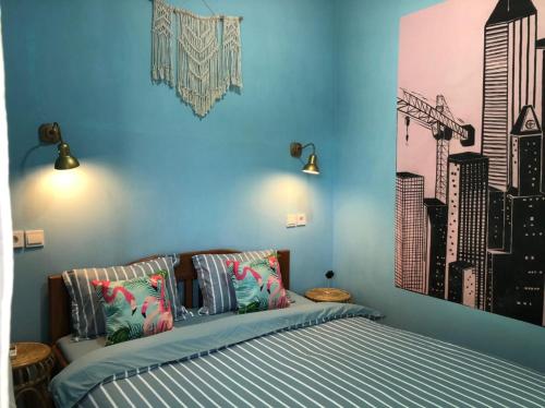 a bedroom with a bed with blue walls at Padang Homestay in Padang