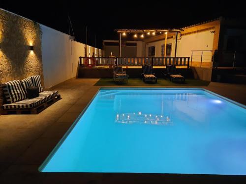 a large swimming pool with blue lights on a patio at Las Eras 2 in Herencia